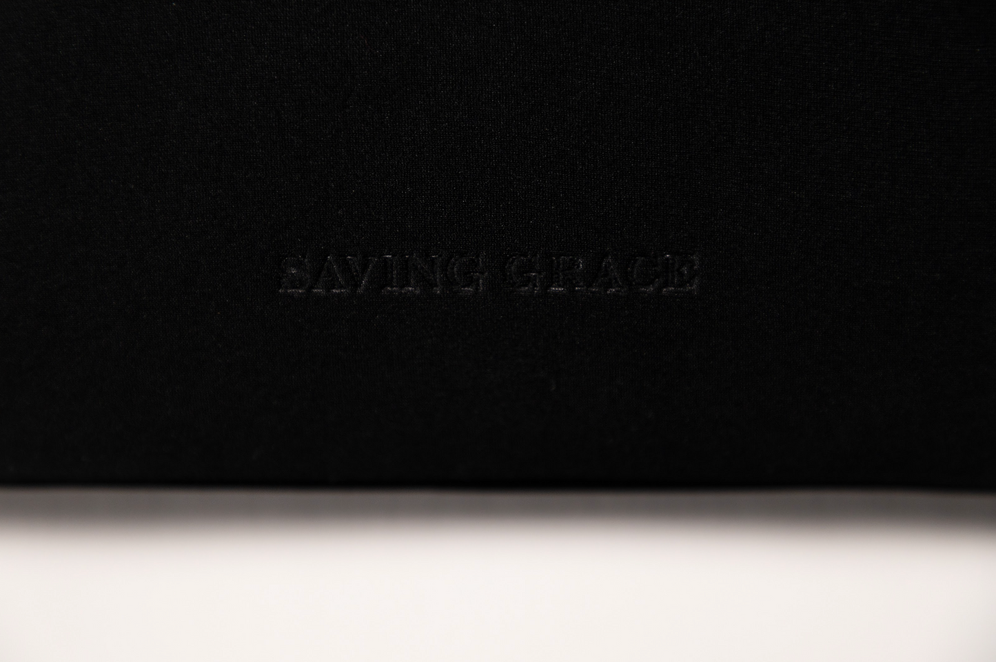 Elegant black neoprene pouch for skincare, structured and flexible, perfect for storing bottles, jars, and tubes of beauty essentials.