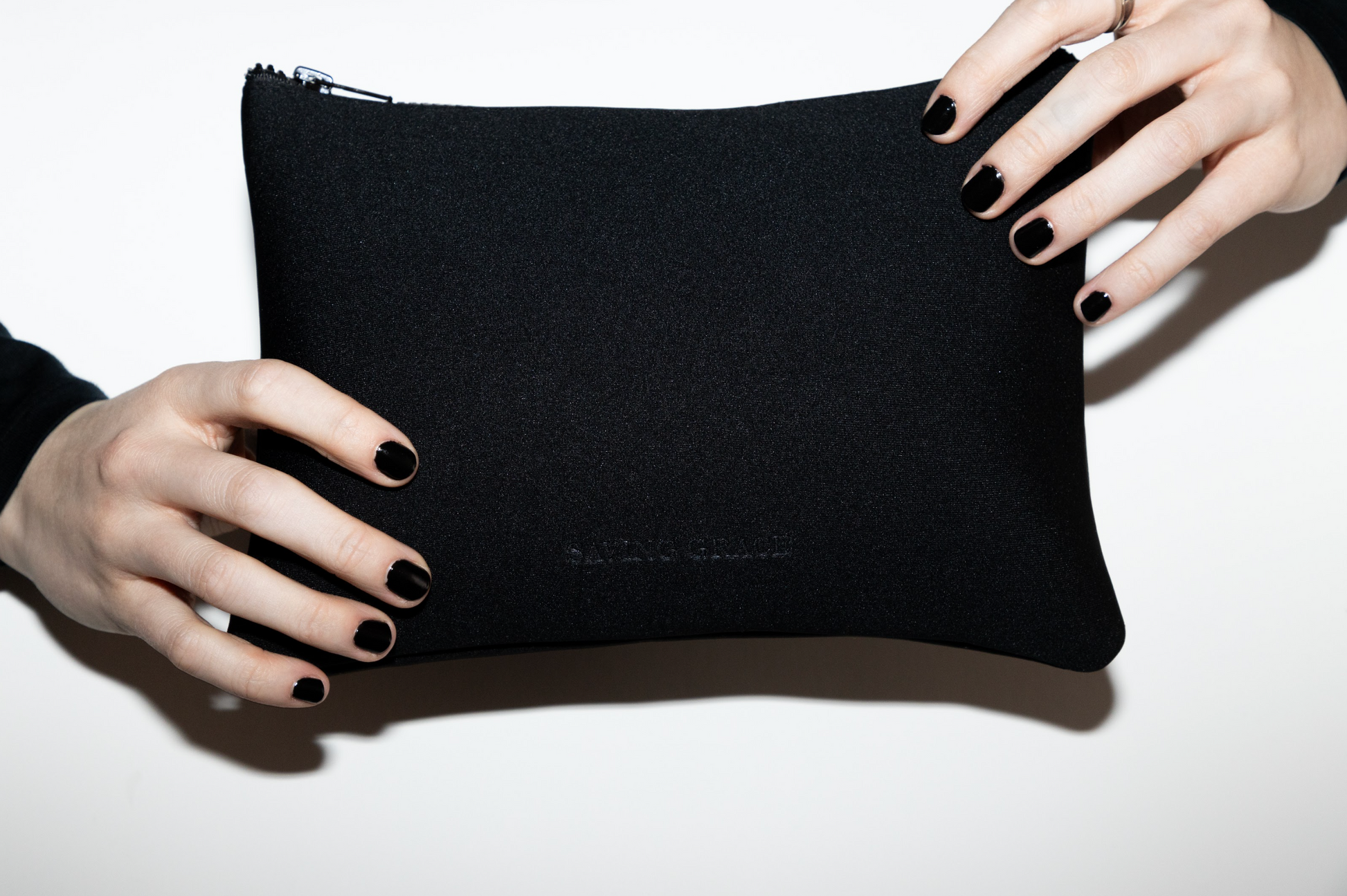 Luxury neoprene skincare pouch in soft black, holding skincare bottles and jars, minimalist travel bag for cosmetics and beauty essentials